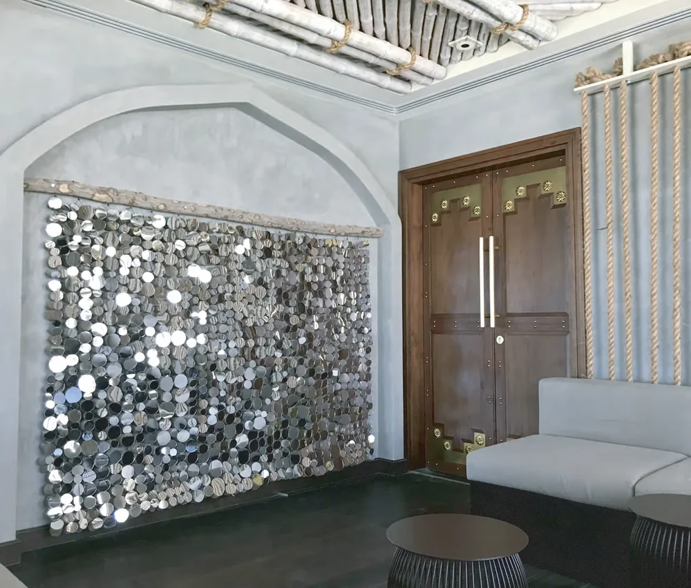 Mirror-and-driftwood tapestry installation by Creative Elements at the Kempinski Hotel, Al Mouj